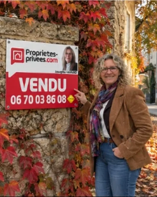 Josepha Favard devant un panneau VENDU, en automne, sous la vigne vierge