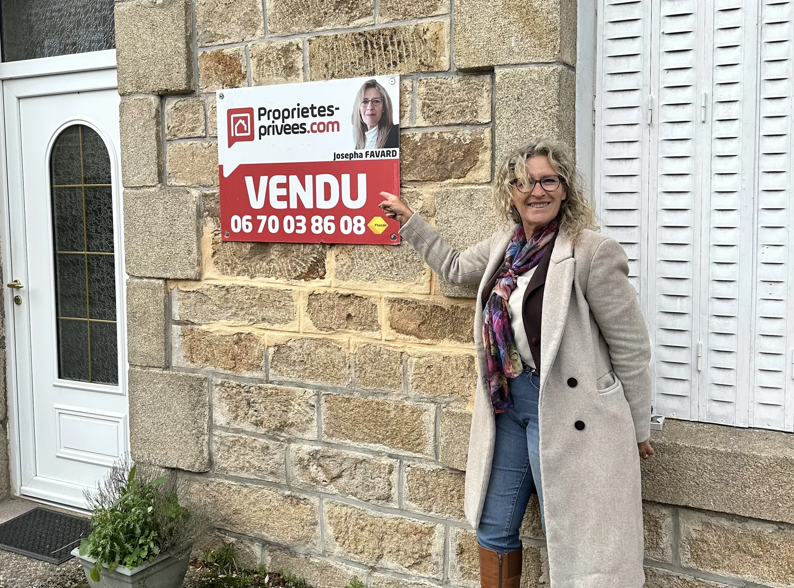 Josepha Favard devant le panneau VENDU d’une maison en pierre du secteur de Treignac